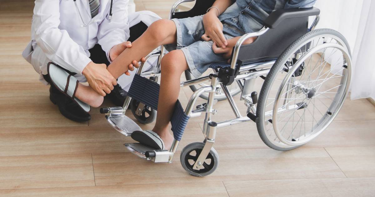 Arts die been van patiënt in rolstoel in het ziekenhuis controleert